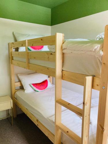 two bunk beds in a room with a green wall at The Red Lion Stevington in Stevington