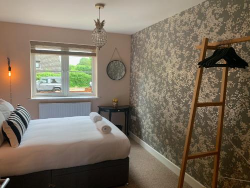 a bedroom with a bed and a ladder in it at The Red Lion Stevington in Stevington