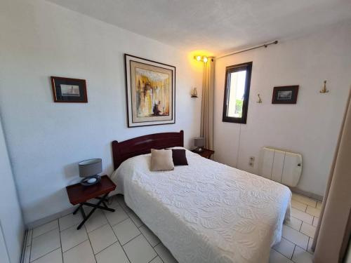 1 dormitorio con cama blanca y ventana en Appartement Argelès-sur-Mer, 2 pièces, 4 personnes - FR-1-388-162, en Argelès-sur-Mer