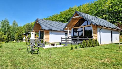 a cabin in the woods with a grass yard at Bieszczadzka Pauza in Polańczyk