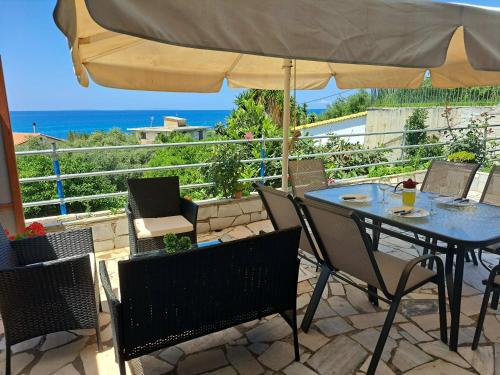 a patio with a table and chairs and an umbrella at Olive tree villa in Ligia