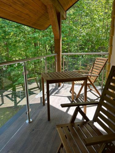 a porch with a wooden table and two chairs at Leśna Residence & SPA in Pisz