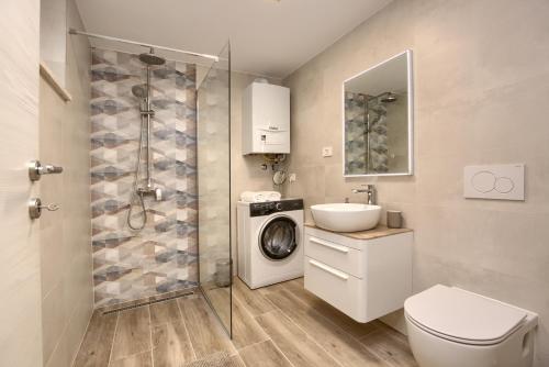 a bathroom with a sink and a washing machine at Apartment Marin 2 near the beach in Banjole