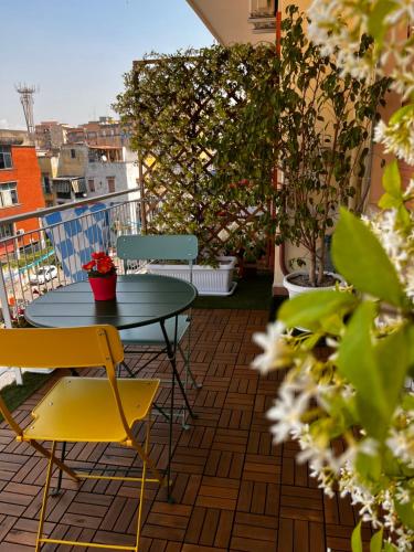 eine Terrasse mit einem Tisch und Stühlen auf dem Balkon in der Unterkunft Frebi's Home - Bed & Breakfast in Neapel