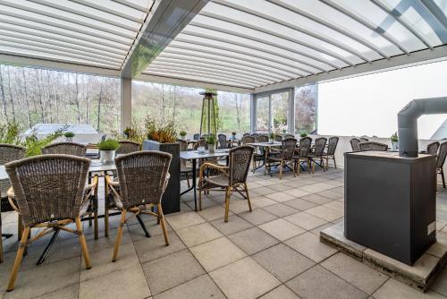 a patio with tables and chairs and a heater at Bierenbacher Hof in Nümbrecht