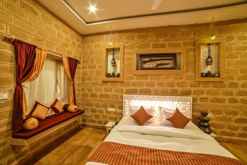 a bedroom with a bed in a brick wall at The Bheemgarh in Jaisalmer