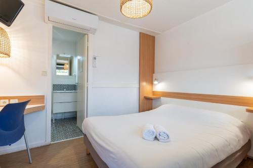a bedroom with a bed and a blue chair at Kyriad Direct Bordeaux Sud Cestas in Cestas
