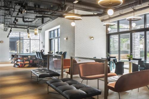 una sala de espera con sillas, mesas y ventanas en Modern Apartments at Enclave located in Central London, en Londres
