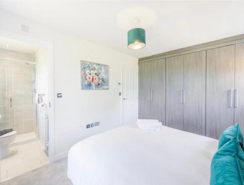 ein Schlafzimmer mit einem weißen Bett und ein Badezimmer in der Unterkunft The Neal's 4 Bedroom House in Buxton Sleeps 8 in Buxton