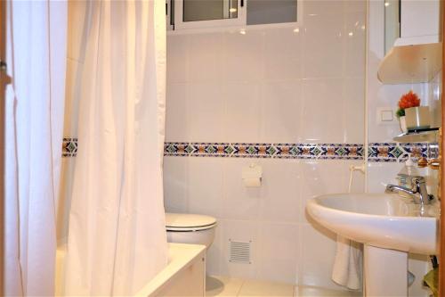 a white bathroom with a toilet and a sink at 29D Vistas espectaculares parking and wifi in Calpe