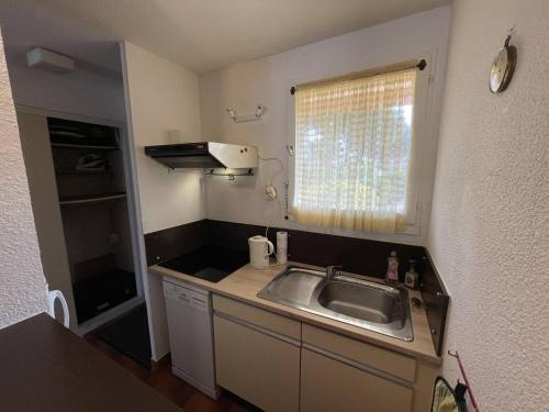 małą kuchnię ze zlewem i oknem w obiekcie T3 calme avec terrasse, clim et parking proche plage - FR-1-106-45 w mieście Saint-Cyprien