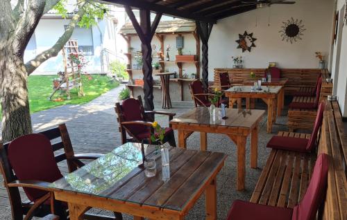 ein Restaurant mit Holztischen und -stühlen und einer Terrasse in der Unterkunft Weingut & Gästehaus Markus Tschida in Apetlon