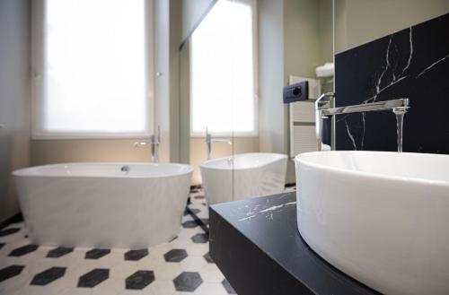 a bathroom with two sinks and two tubs at Hotel Astoria in Genova