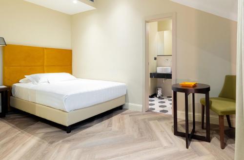 a bedroom with a bed and a table and a chair at Hotel Astoria in Genova