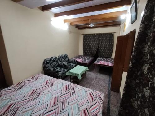 Cette chambre comprend deux lits, un lit et un canapé. dans l'établissement HERITAGE HOMESTAY@OLD CITY NEAR GANGES, à Varanasi