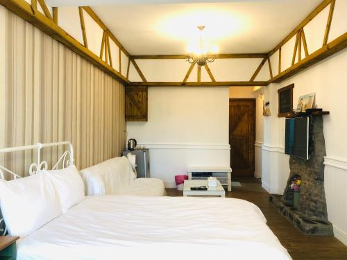 a bedroom with a white bed and a couch at 海沐輕旅 Sea Mu Kenting in Nanwan
