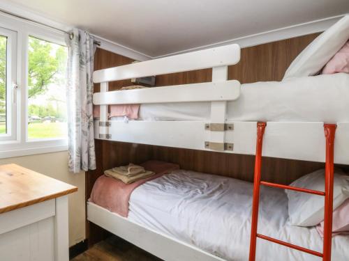 a bunk bed room with two bunk beds and a desk at Ardea in Norwich