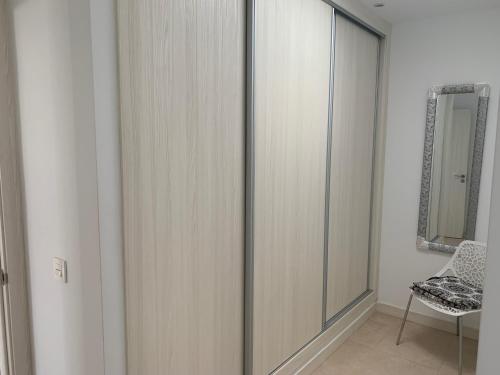 szafa ze szklanymi drzwiami i krzesłem w pokoju w obiekcie Villa Stella Maris w mieście Playa Blanca
