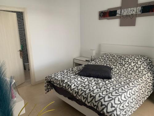 sypialnia z łóżkiem z czarno-białą kołdrą w obiekcie Villa Stella Maris w mieście Playa Blanca
