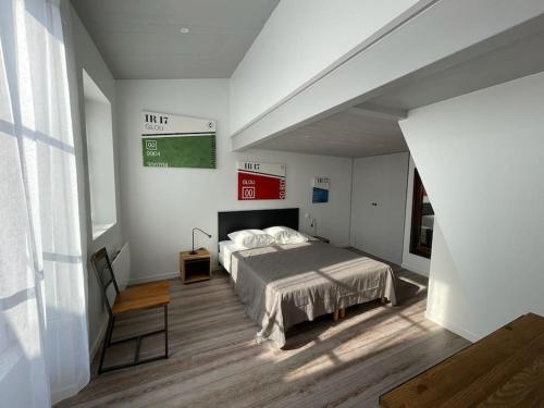 - une chambre avec un lit et un panneau vert sur le mur dans l'établissement Grand appartement ancien en centre ville, à La Rochelle