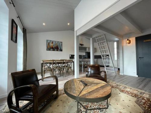 un salon avec une table et des chaises et une cuisine dans l'établissement Grand appartement ancien en centre ville, à La Rochelle