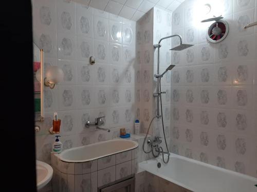 a bathroom with a tub and a sink and a shower at Apartment ЖУЖУНА in Batumi