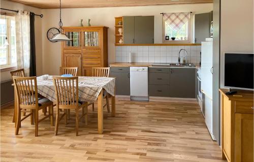 cocina con mesa y sillas y TV en Beautiful home in Vittaryd with 3 Bedrooms and WiFi, en Kvänarp