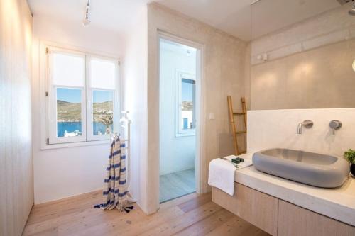 łazienka z umywalką i prysznicem z oknem w obiekcie Villa Island , Luxury Villa in Mykonos w mieście Agia Anna