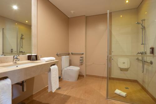 a bathroom with a shower and a sink and a toilet at Vila Gale Collection Palácio dos Arcos in Oeiras
