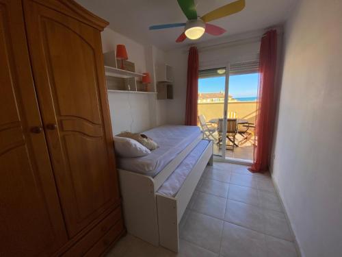 Un pequeño dormitorio con una cama y una puerta a un patio en Sierra Irta Altamar, en Alcossebre