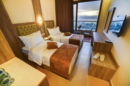 a hotel room with two beds and a television at De-Lara hotel in Aqaba