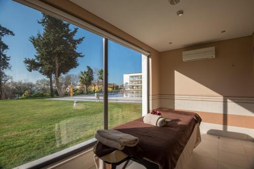 a large window in a room with a bed in front of it at Vila Gale Collection Palácio dos Arcos in Oeiras
