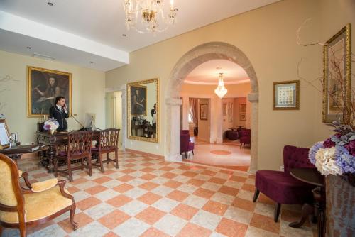 a man standing at a table in a living room at Vila Gale Collection Palácio dos Arcos in Oeiras