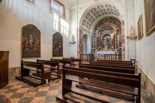 a church with wooden pews and a large altar at Vila Gale Collection Palácio dos Arcos in Oeiras