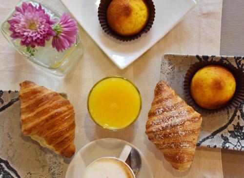 a table topped with pastries and a cup of orange juice at Locanda Sighimi in Lanusei