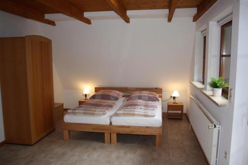 ein Schlafzimmer mit einem Bett mit zwei Kissen darauf in der Unterkunft Heidhöhe, Ferienwohnung in Jesteburg