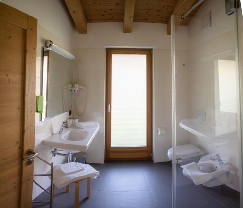 a bathroom with two sinks and a glass shower at Garnì Tuttotondo in Levico Terme