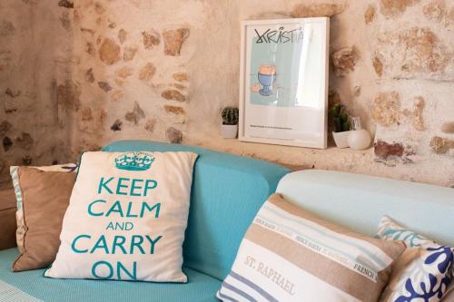 a blue couch with a keep calm and carry on pillow at A9 - 1 BDR Fantastic Sea View Remparts Old Antibes - AC in Antibes