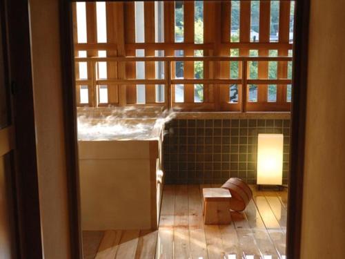 a room with a window and a table and a bench at Ryokan Sumiya Kihoan in Kameoka