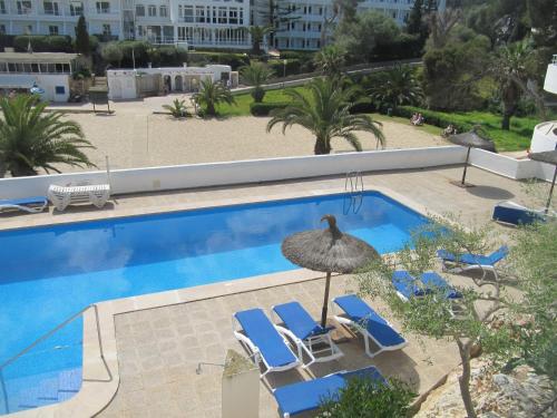 a swimming pool with two lounge chairs and an umbrella at Beach Suite Playa Cala dor in Cala d´Or
