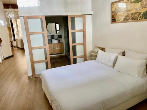 a white bed with white pillows in a room at Loft hyper centre in Avignon