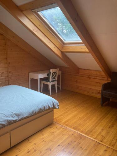 um quarto com uma cama e uma secretária num sótão em Houten chalet/bungalow in het bos, sauna, jacuzzi em Meijel