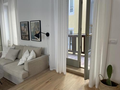 a living room with a couch and a balcony at Studio Apartment Old Town Riva in Riva del Garda