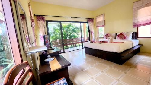 a bedroom with a bed and a large window at Sawaddee Aonang Resort in Ao Nang Beach