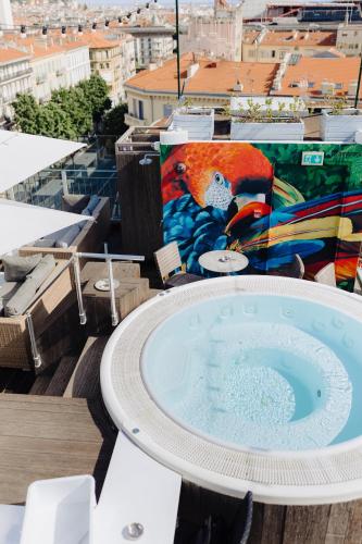 a hot tub on top of a building with a painting at Hôtel & Appartements Monsigny in Nice