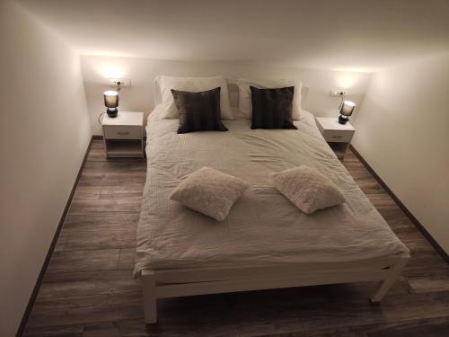 Apartment Loft في سيني: سرير كبير ومخدات عليه في غرفة النوم
