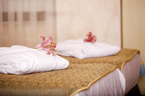 two beds with white pillows and flowers on them at Edibe Sultan Hotel in Istanbul