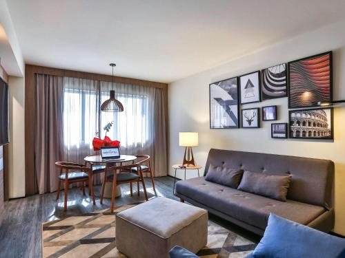a living room with a couch and a table at Novotel Sorocaba in Sorocaba