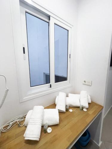 a group of towels sitting on a wooden table in front of a window at Canary Dream Studio in Las Palmas de Gran Canaria