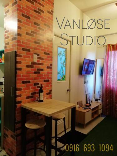 Habitación con mesa y pared de ladrillo en NAIA Airport Vanløse Studio by Velkommen Guest PH en Manila